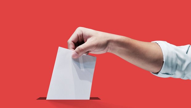 Symbolbild einer Hand mit Stimmzettel.