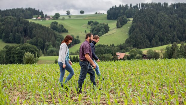 Ihren Mais schützen Roman (rechts, blaue Jacke), Silvia und Erich Siegenthaler mit Duftstoffen gegen gefrässige Emmentaler Hirsche. Bild: die grüne/Pia Neuenschwander