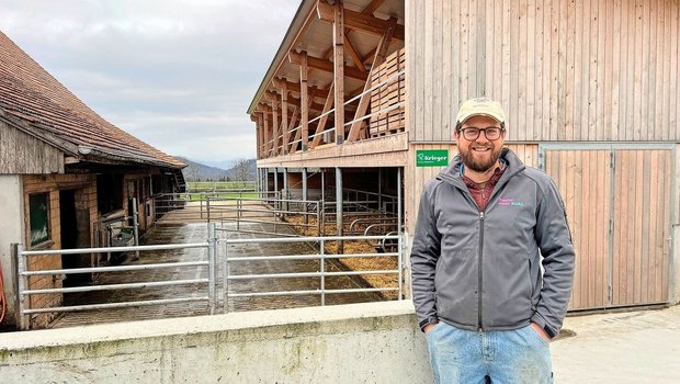 Christof Bühler vor dem Mutterkuhstall (vorne) und Pferdestall (hinten). Im alten Stall wurde nur innen investiert, und zwar in Liegeboxen, Fressachse und Abkalbebox.