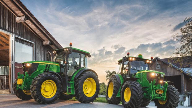 Zwei John Deere-Traktoren im Gegenlicht.