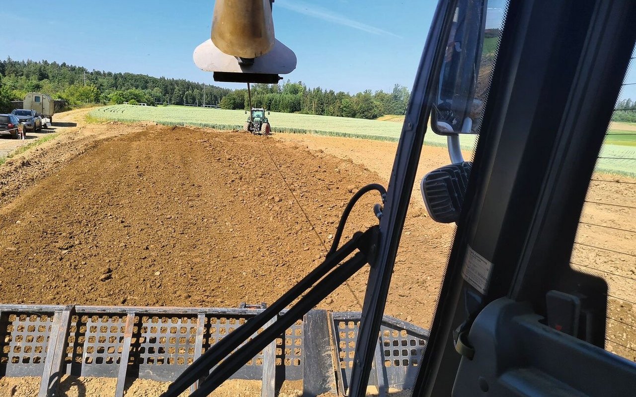 Am Traktor ist die Seilwinde verankert. Die Winde verbessert die Schubkraft, indem durch den Zug am Seil die Raupenauflage optimiert wird.