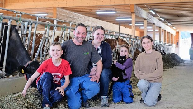 Michael und Katrin Stalder mit ihren Kindern Manuel, Salome und Lena (v.r.n.l.) im neu gebauten Laufstall. Dank der neuen Technik wie Melk- und Mistroboter bleibt nun mehr Zeit für die Familie.