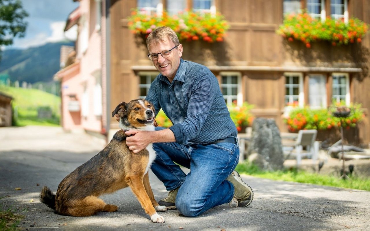 Stefan Müller und sein Appenzeller Bläss vor dem Bauernhaus.