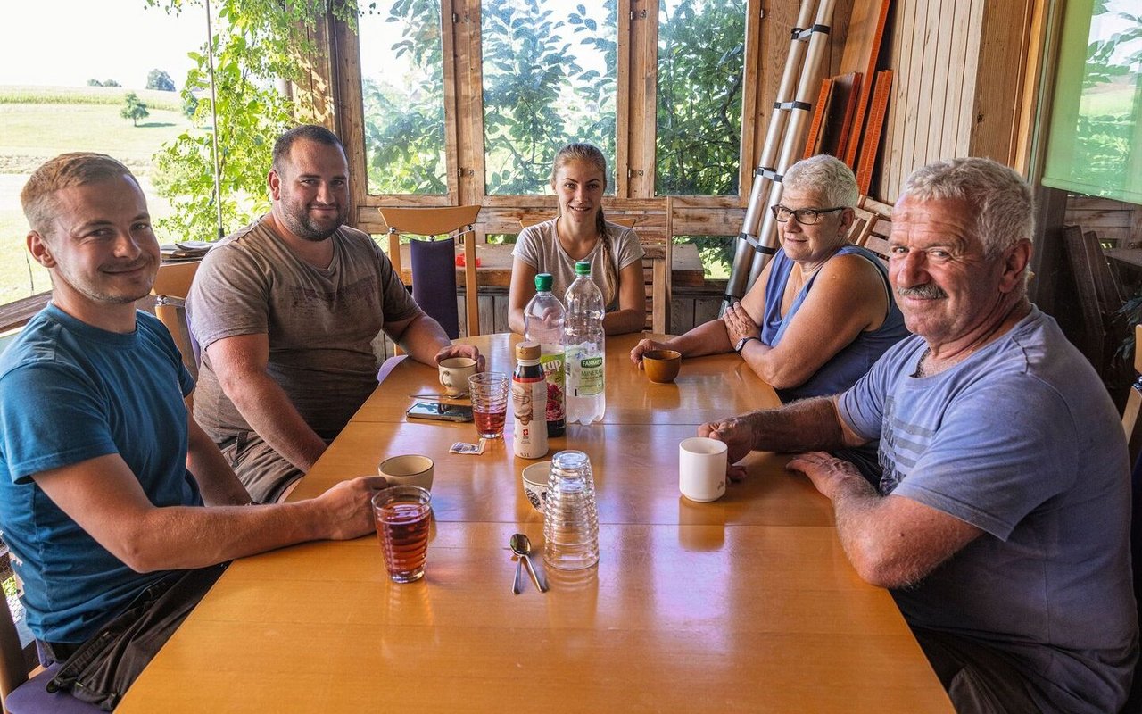 Familie Duperrex sitzt mit Kati Fábián und Jan Burkhard beim Frühstück.