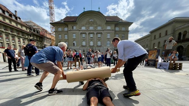 Bauern und Bäuerinnen werden von einer symbolischen «Walze der Grossverteiler» überrollt