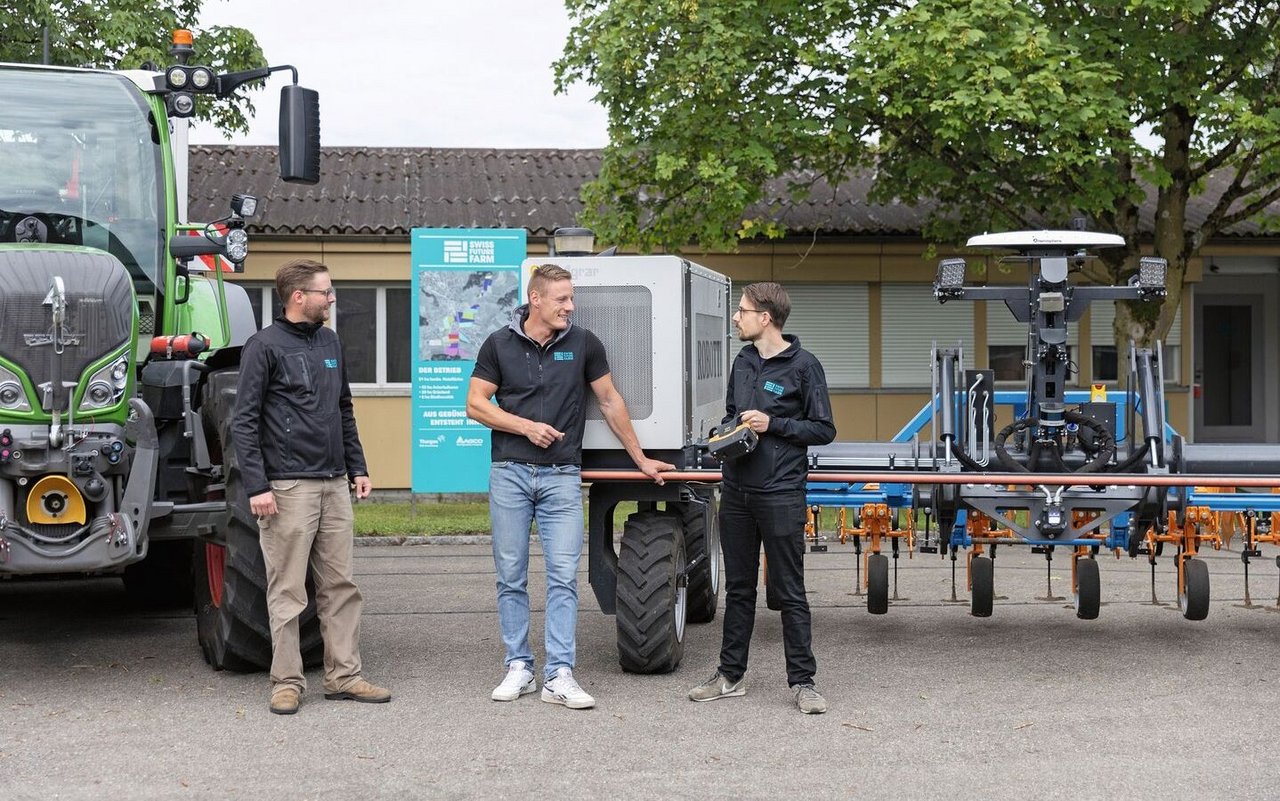 Nils Zehner (AGCO) Roman Gambirasio (GVS)und Florian Abt (Arenenberg) stehen vor einem Fendt-Traktor sowie einem Feldroboter.