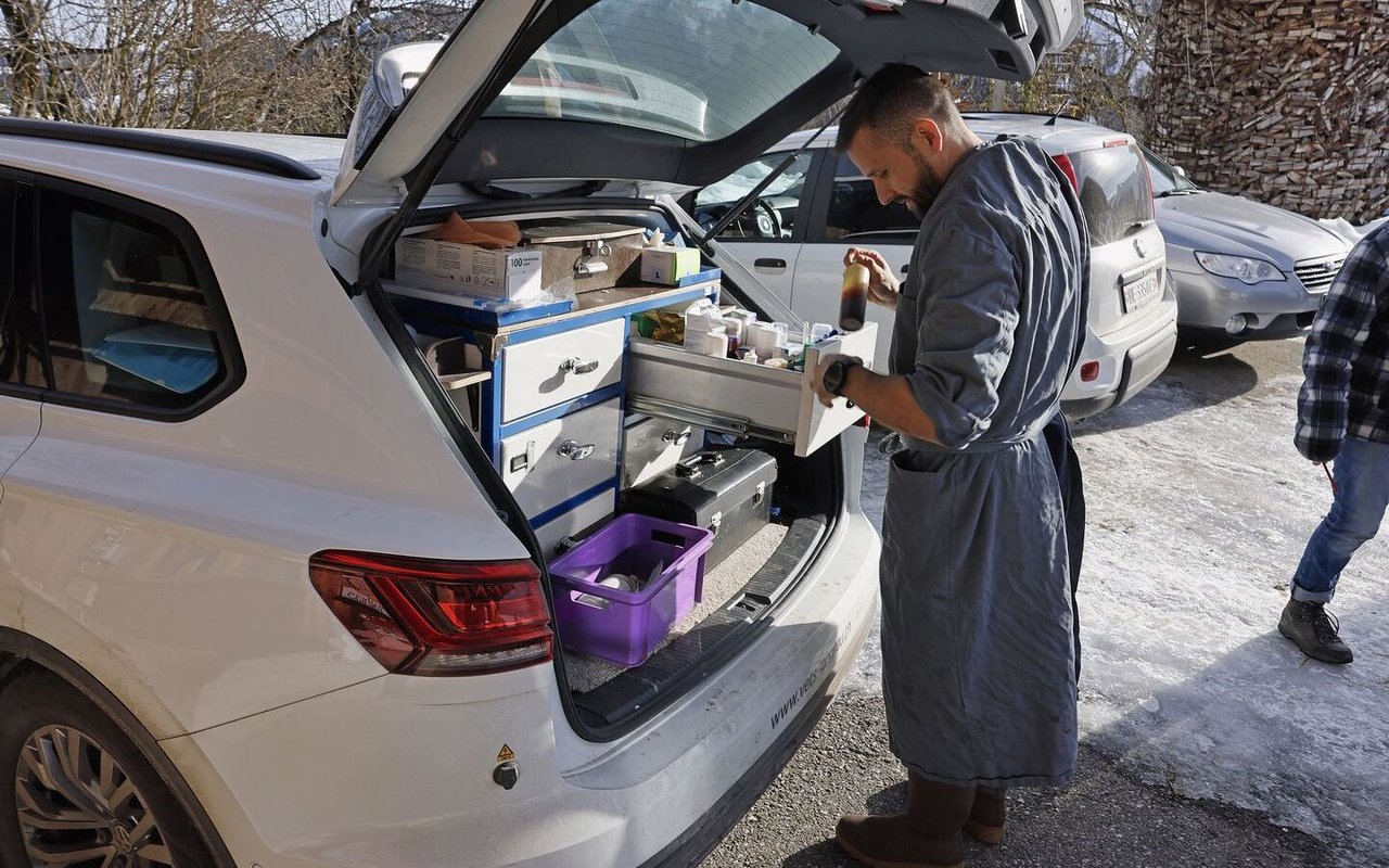 Martin Blaser zieht eine Schublade im Schränkchen in seinem Auto heraus, um ein Behandlungsmittel zu finden.