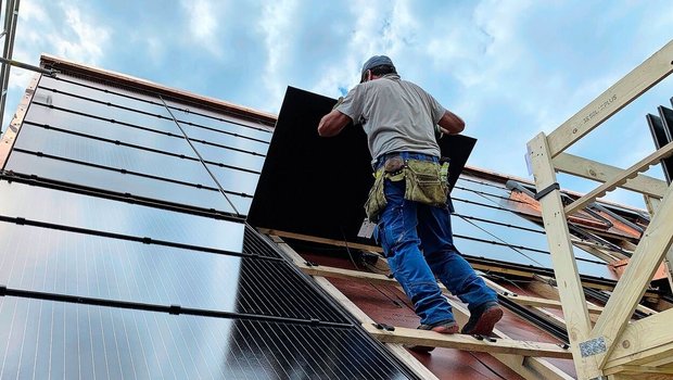 Montage von PV-Modulen für eine Indachanlage auf einem Neubau. Solche Systeme sind zwar teurer als Aufdachanlagen, dafür können die Ziegel eingespart werden.