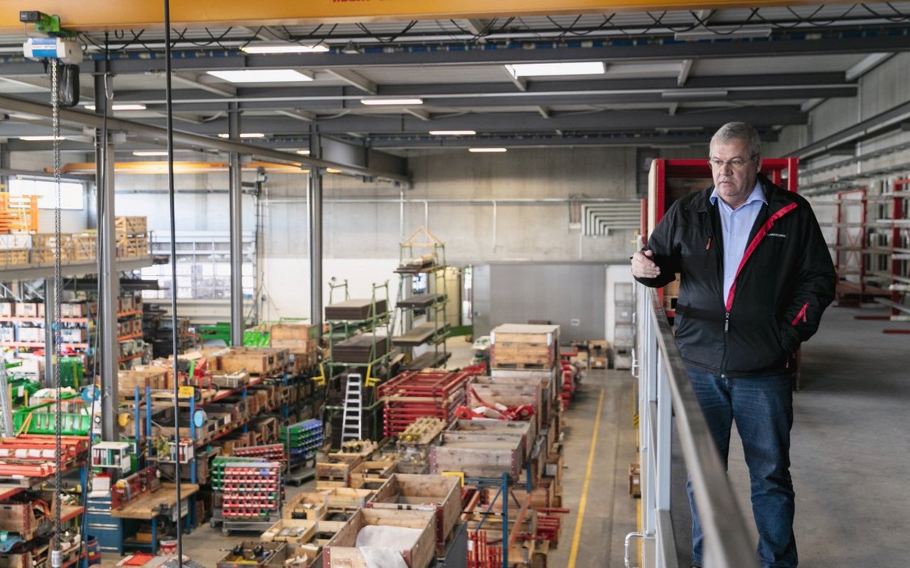 Verkaufschef Karl Tanner erklärt die Abläufe in der Produktionshalle. Die Halle ist in der Mitte geteilt. Hier der Blick in die Ladewagen-Produktionsstrasse. Rechts der Wand sind die Montageboxen für den Fassbau platziert. Bild: Mareycke Frehner