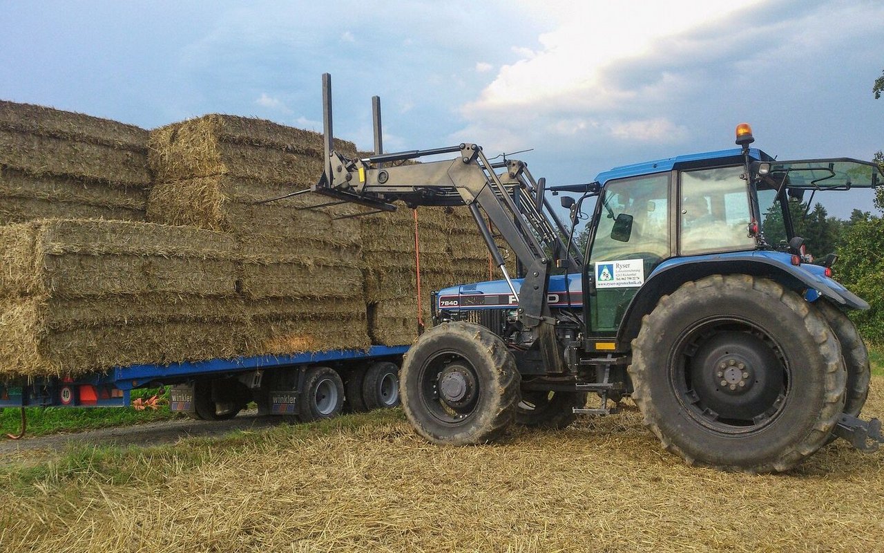 Beim Ballenauflad wird der Anhänger am Feldrand fertig verladen, damit er nicht mit seinem vollen Gewicht den Ackerboden belastet.