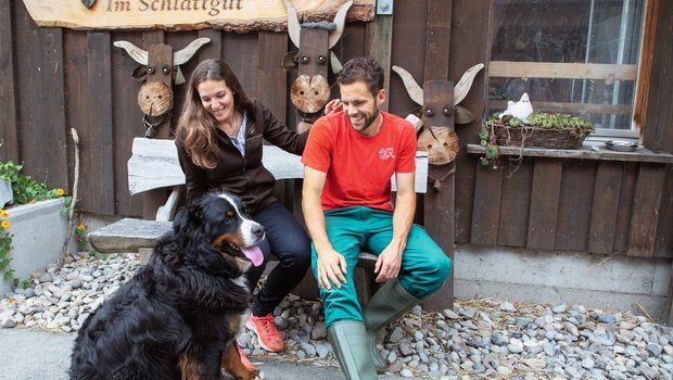 Ruhige Momente auf der Bank vor der Event-Scheune sind bei Caroline Wyss und Domenik Ledergerber rar – auch Hofhund Maiko will dabei sein. Bild: Gian Vaitl