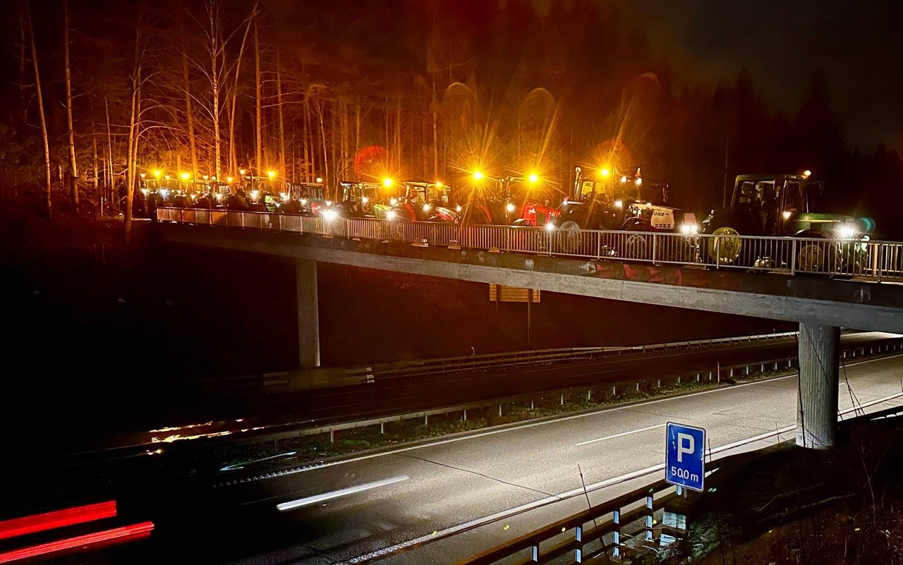 Traktoren mit Rundumleuchten über der Autobahn A6.