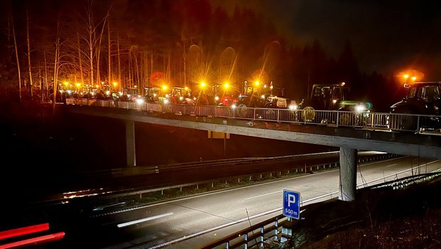 Traktoren mit Rundumleuchten über der Autobahn A6.