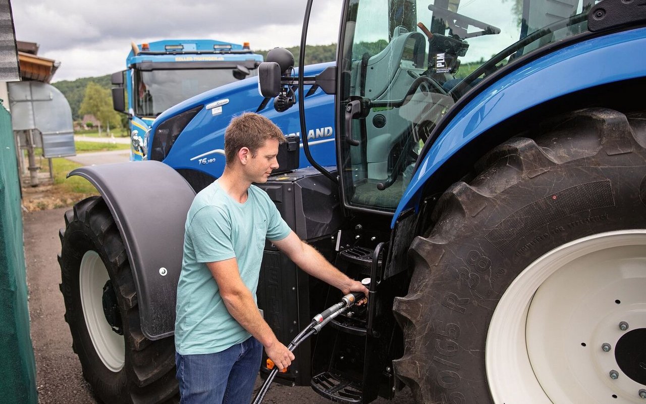 Der Traktor wird schnell und einfach mit Biogas vom Hof betankt. Dahinter wartet der Kehrichtwagen. Die Entsorgungsfirma Keller hat zum Start der Biogas-Tankstelle ein neues gasbetriebenes Kehrichtauto gekauft und ein weiteres bestellt. 