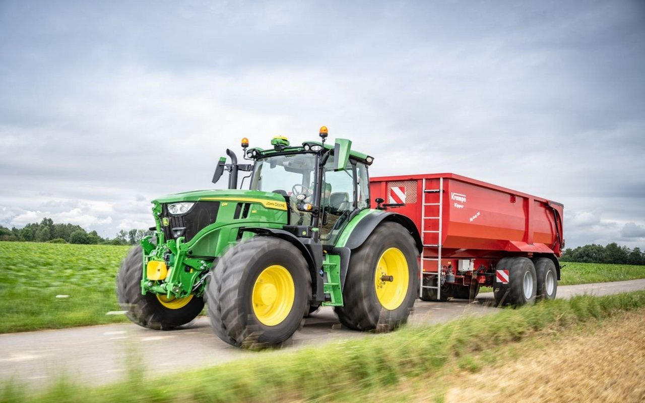 Der John Deere 6R Traktor mit Anhänger.