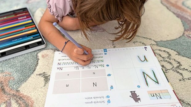 Auf dem Teppich statt am Tisch: Martina Brühlmann plädiert dazu, das Kind den Ort für die Hausaufgaben selbst wählen zu lassen. Wenn es lieber liegt oder steht, warum nicht? Sitzen muss es in der Schule schon viel. 
