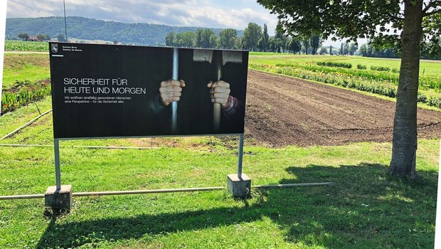 Erst auf den zweiten Erst auf den zweiten Blick erkennt man, dass auf dem Plakat der JVA eine Hand ein Zellengitter und die andere den Stiel einer Schaufel umfasst.