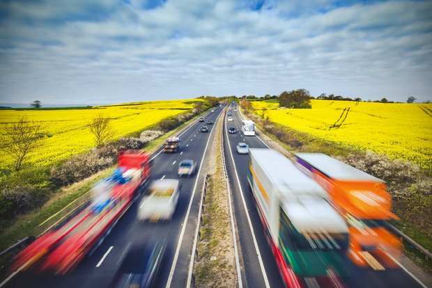 Strassenverkehr auf einer Autobahn mitten in Landwirtschafts-Land. Bild: Adobe