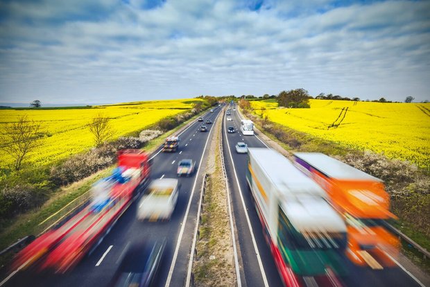 Faktencheck: Nutztierhaltung verursacht grosse Treibhausgas-Emissionen Strassenverkehr auf einer Autobahn mitten in Landwirtschafts-Land. Bild: Adobe