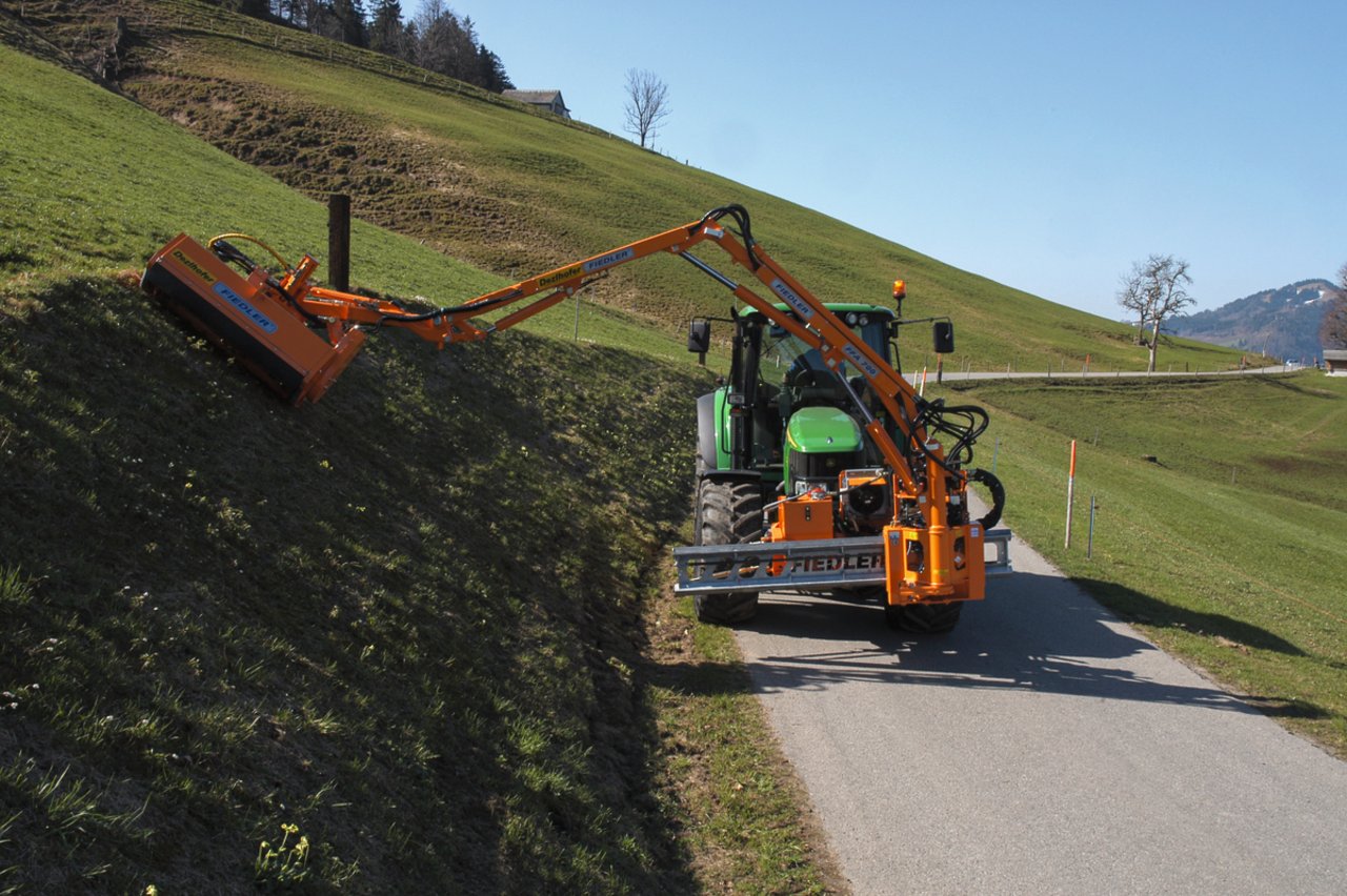 Der Fiedler Kommunal-Frontausleger FFA 700 ist an alle gängigen Fahrzeugtypen anbaubar, hier an einem John Deere 6420. Mit dem flexiblen und leistungsfähigen Böschungsmäher pflegt dieser Landwirt einen steilen Strassenrand. Bild: zVg