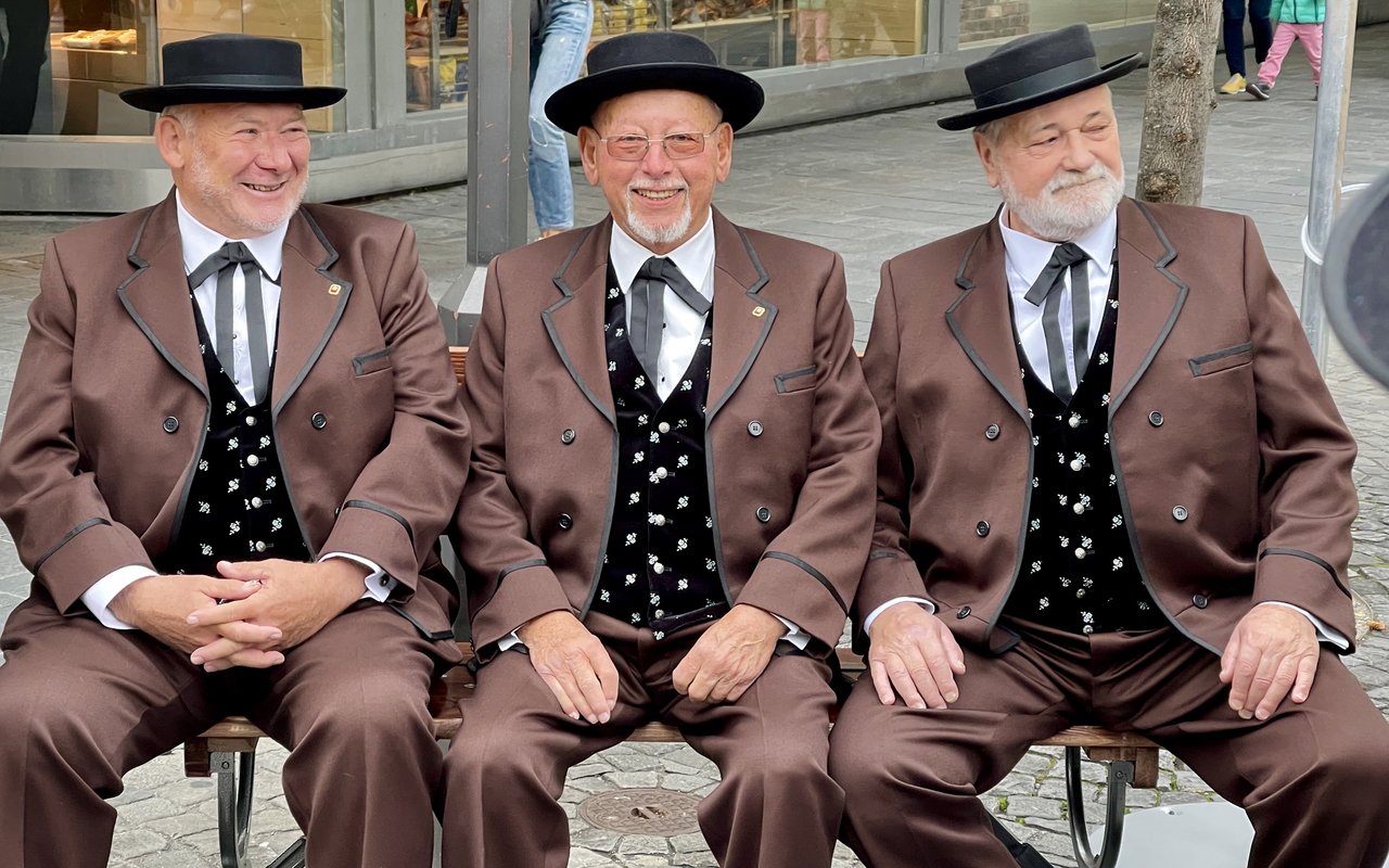 Drei Männer vom Jodelchor Bärgfründe aus Thun sitzen auf einer Bank, die die drei Sennen aus der Appenzeller-Werbung.