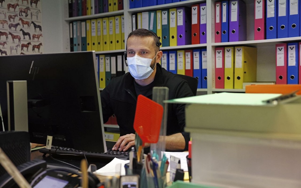 Martin Blaser sitzt im Büro, trägt Kopfhörer und telefoniert mit Kunden.