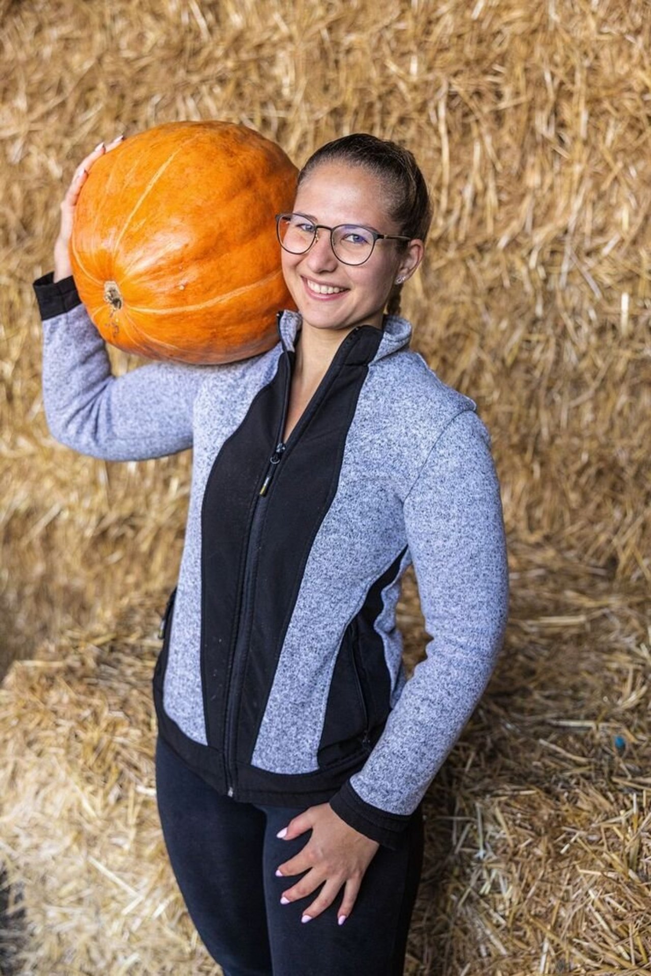 Faye Kleiner schultert einen Kürbis.