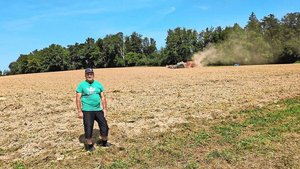 Beat Mathys mit dem Beat Mathys mit dem Agbot im Hintergrund. Leicht kann vergessen werden, dass der Feldroboter autonom fährt, so unscheinbar ist er.