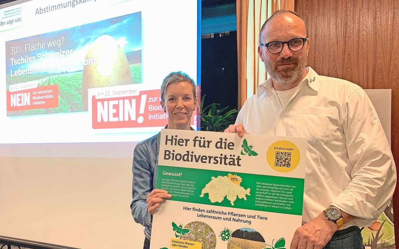 Thomas Rickenbacher und Sandra Helfenstein präsentieren das Plakat, dass auf Höfen auf die vielen bereits bestehenden Biodiversitäts-Förderflächen hinweisen soll. 