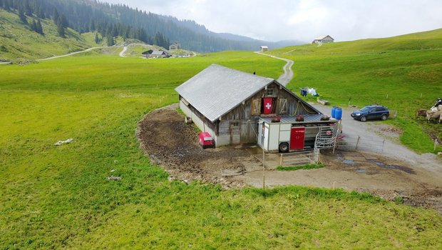 Der Melkroboter auf der Alp Pragel mit Milchtank und den Kraftfutterfässern auf dem Dach des Melkroboters.