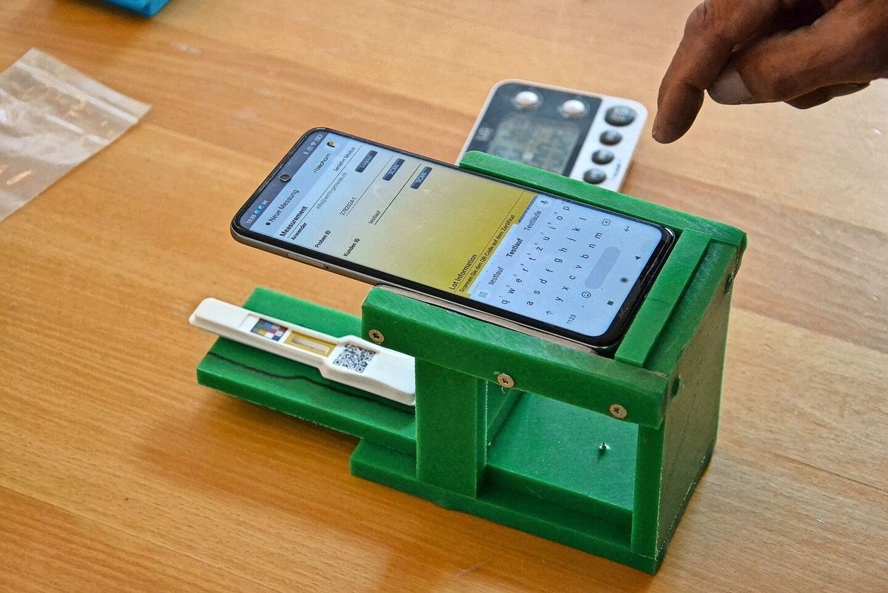 Die Distanz zwischen Smartphone und DON-Test beeinflusst das Ergebnis der Messung. Das grüne Gestell sorgt für einen einheitlichen Abstand. 