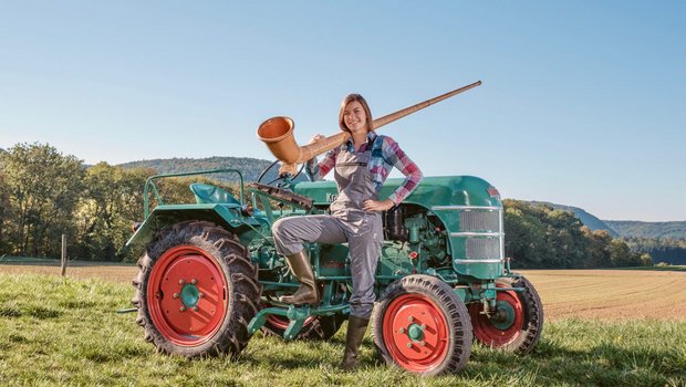 Alphorn-Solistin Lisa Stoll mit ihrem «Traum-Traktor», einem Kramer K15. Bild: zVg