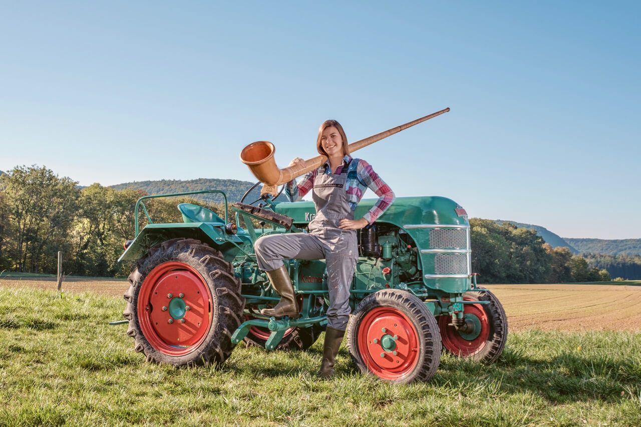 Alphorn-Solistin Lisa Stoll mit ihrem «Traum-Traktor», einem Kramer K15. Bild: zVg